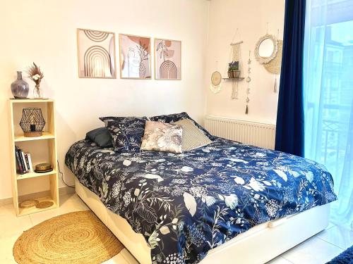 une chambre avec un lit avec une couette bleue et blanche dans l'établissement Studio cosy à 15 min de Bastille, à Alfortville