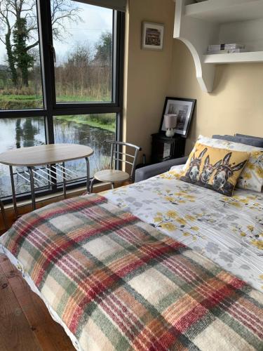 ein Schlafzimmer mit einem Bett und einem großen Fenster in der Unterkunft Red Sheds Cabin in Portarlington
