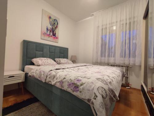 a bedroom with a green bed and a window at Apartman Green City with garage in Banja Luka