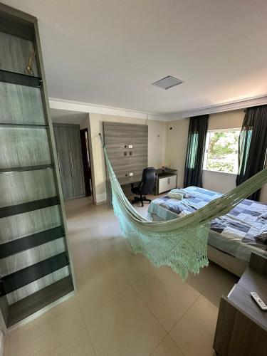 a hammock in a room with a bed and a desk at Pousada Olho D'água in São Luís