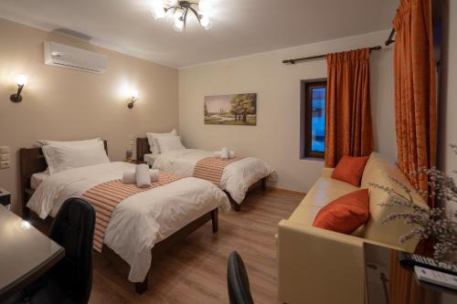 a hotel room with three beds and a couch at Voulas Traditional House Meteora 1 in Kalabaka