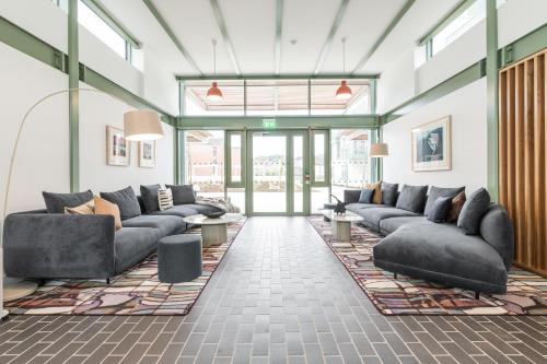 a living room with couches and tables and windows at The Lookout in Dublin