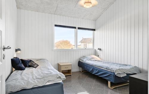 オテルプにあるAmazing Home In Otterup With 3 Bedrooms, Sauna And Wifiのベッドルーム1室(ベッド2台、窓付)