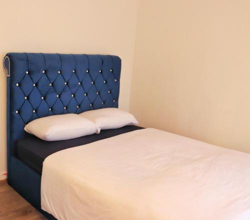 1 cama con cabecero azul y almohada blanca en Deluxe Dwelling - 15 mins from Cork City/Airport en Cork