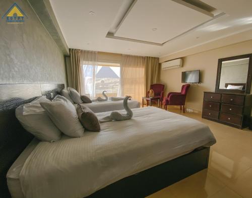a bedroom with a large bed with swans on it at Egypt Pyramids Inn in Cairo