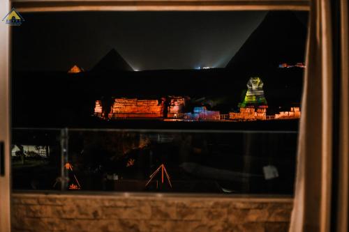 a view of a city at night from a window at Egypt Pyramids Inn in Cairo