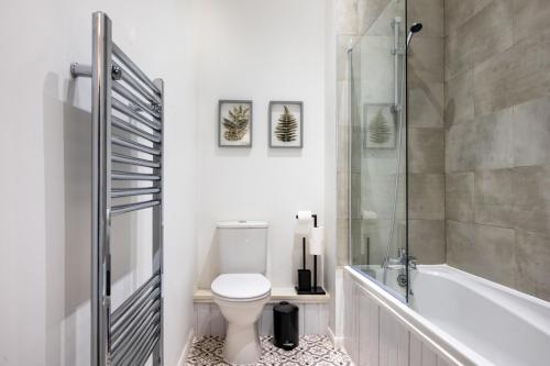 een witte badkamer met een toilet en een douche bij Home in West Yorkshire, Close to Leeds City Center, Sleeps 3! in Batley