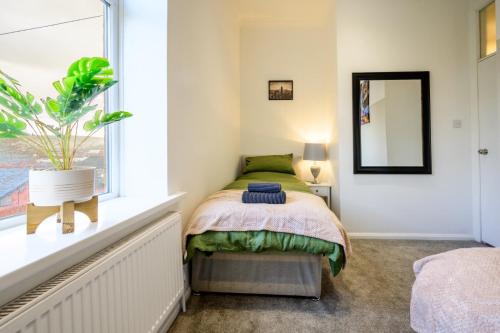 een slaapkamer met een bed en een raam bij Home in West Yorkshire, Close to Leeds City Center, Sleeps 3! in Batley