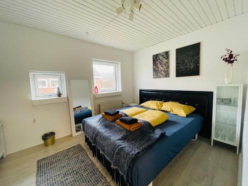sypialnia z niebieskim łóżkiem z żółtymi poduszkami w obiekcie 1 private room in Billund w Billund