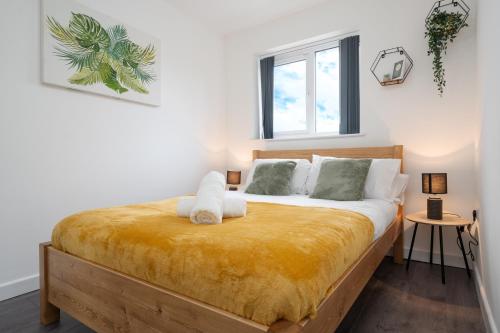 een slaapkamer met een groot bed en een gele deken bij Dazzling & Modern 4bd - Nr Etihad - Parking -EV in Manchester