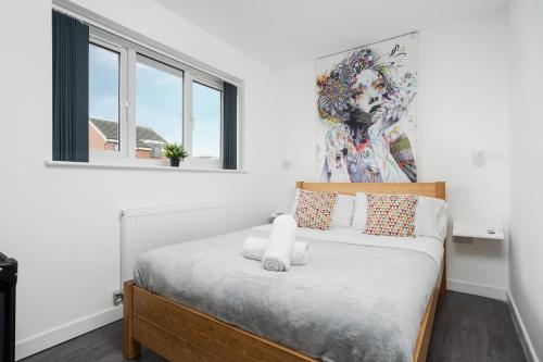 een slaapkamer met een bed met een schilderij aan de muur bij Dazzling & Modern 4bd - Nr Etihad - Parking -EV in Manchester