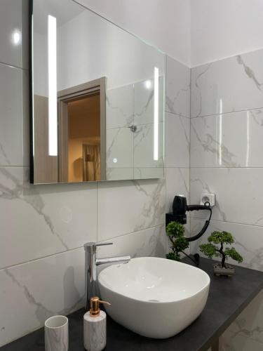 een badkamer met een witte wastafel en een spiegel bij Compass Lofts Athens in Athene