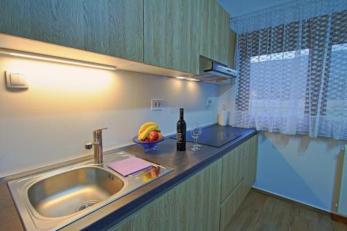 a kitchen with a sink and a bowl of fruit at Holiday Home Sinac 2 in Otočac