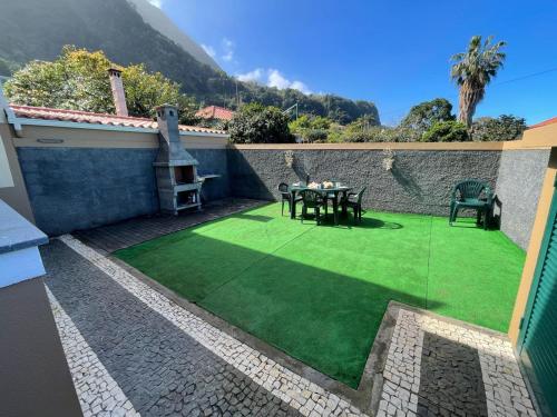 a patio with a table on a green lawn at Wanderlust House in Ponta Delgada