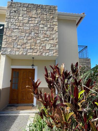 a house with a brown door and some plants at Wanderlust House in Ponta Delgada
