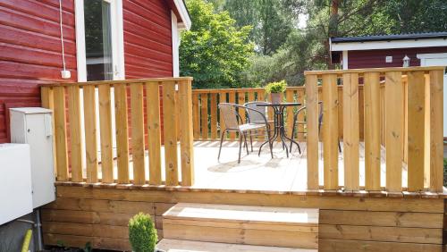 a wooden deck with a table and chairs on a house at Komplett lägenhet med sjöutsikt in Malmön