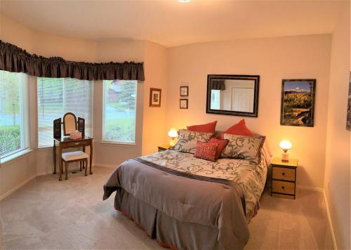 Schlafzimmer mit einem Bett, einem Schreibtisch und Fenstern in der Unterkunft Lakeside house in Anchorage