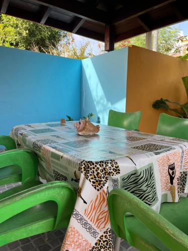 a table with green chairs and a table cloth at La Belle Escapade in Quartier du Fond Fleuri