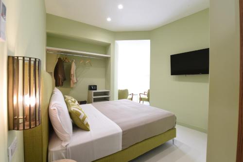 una camera con letto e TV a schermo piatto di Sorrento Rooms Deluxe a Sorrento