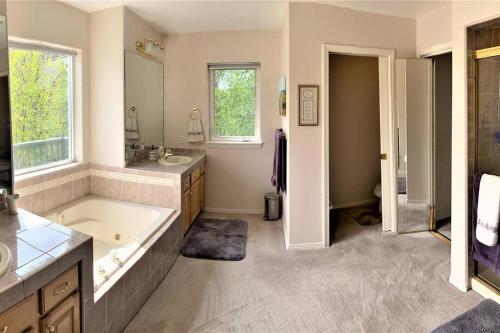 ein großes Bad mit einer Badewanne und einem Waschbecken in der Unterkunft Lakeside house in Anchorage