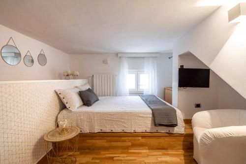 コラートにあるCesarotti B&Bの白いベッドルーム(ベッド1台、テレビ付)