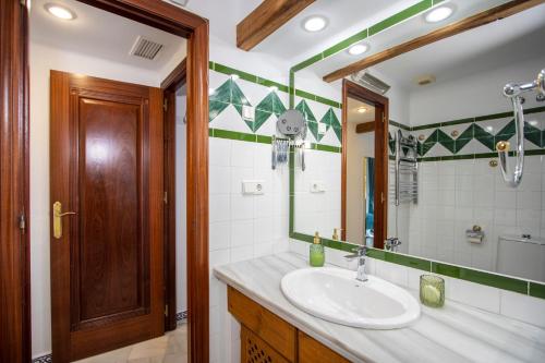 een badkamer met een wastafel en een spiegel bij Aldea del Mar Buganvilla Apartament in Torrevieja