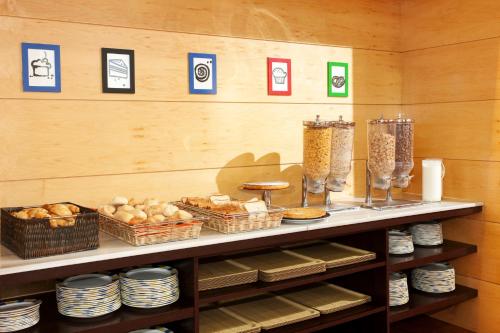 a shelf with plates and baskets of food on it at Holiday Inn Express Molins de Rei by IHG in Molins de Rei