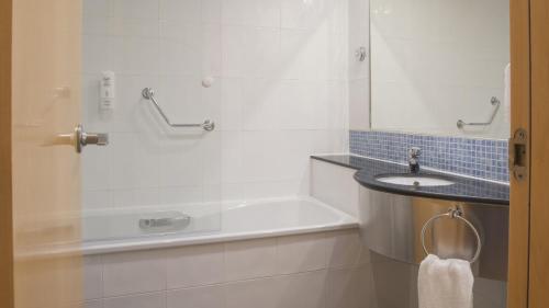 a bathroom with a bath tub and a sink at Holiday Inn Express Molins de Rei by IHG in Molins de Rei