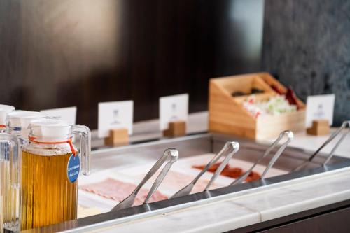 a counter with a glass jar of beer and a box of meat at Holiday Inn Express Molins de Rei by IHG in Molins de Rei