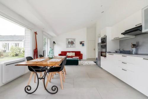 Il dispose d'une cuisine et d'un salon avec une table et des chaises en bois. dans l'établissement Villa entourée de verdure avec parking privé, à Halluin