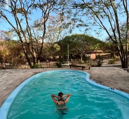 una persona sdraiata in una piscina di EcoPousada Pico do Jabre a Matureia