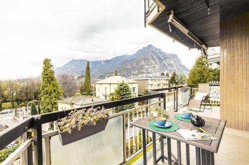 a balcony with a table and a view of mountains at Big Deluxe apts Italian Style Lake&Terrace in Lecco