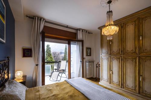 a bedroom with a bed and a chandelier at Big Deluxe apts Italian Style Lake&Terrace in Lecco