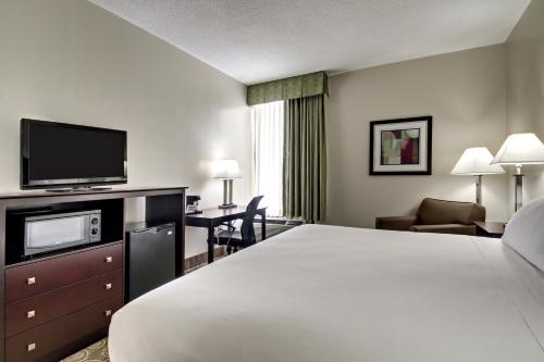 a hotel room with a bed and a flat screen tv at Holiday Inn Express Marshfield - Springfield Area, an IHG Hotel in Marshfield