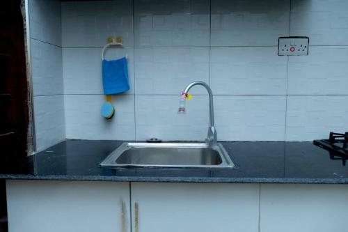 a kitchen counter with a sink and a blue towel at Kazi apartment in Dar es Salaam