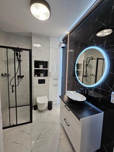 a bathroom with a sink and a mirror at Apartament - Osiedle Przylesie in Namysłów