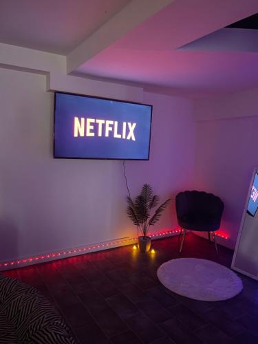 une chambre avec un panneau netflix sur un mur avec des lumières dans l'établissement Shadow Room, à Nîmes