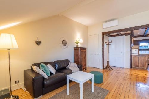 un salon avec un canapé en cuir et une table dans l'établissement LE NOTRE DAME - Beautiful apartment in the heart of the old town, à Annecy