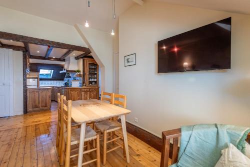 une salle à manger avec une table et une télévision au mur dans l'établissement LE NOTRE DAME - Beautiful apartment in the heart of the old town, à Annecy