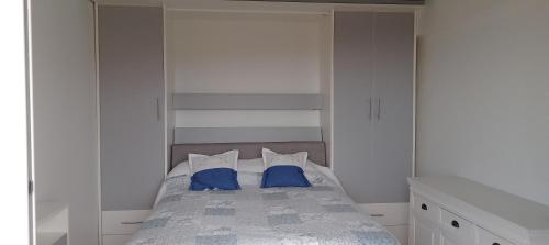 une chambre avec un lit avec deux oreillers bleus dans l'établissement Haut de Mazet vue mer et piscine partagée, à Roquebrune-sur Argens