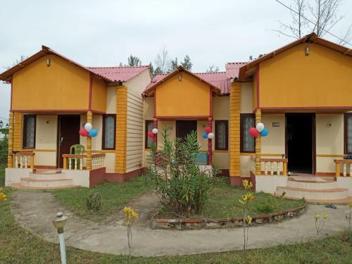 a row of houses with balloons in front of them at Resort Green Earth in Tajpur