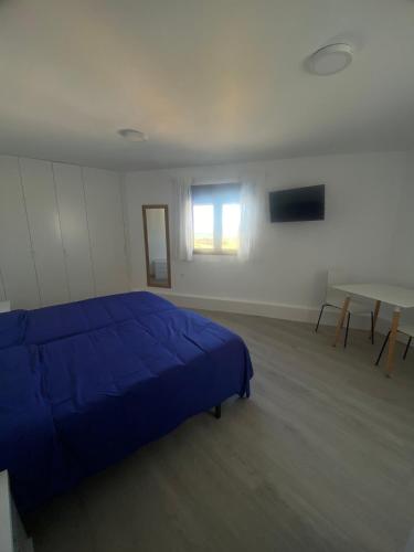 a bedroom with a blue bed and a table at EL RINCÓN DE DENVER in Suances