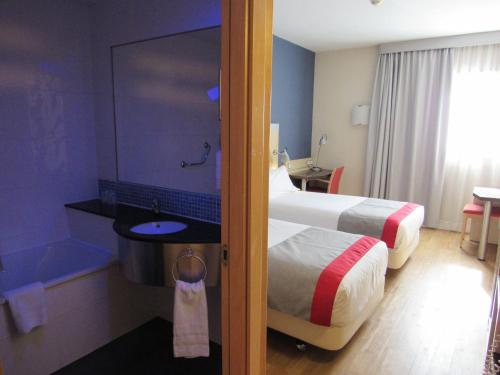 a hotel room with a bed and a bathroom at Holiday Inn Express Madrid-Getafe by IHG in Getafe