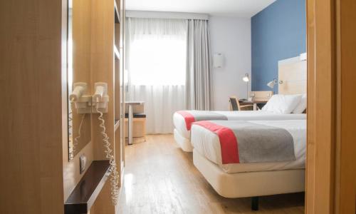ein Hotelzimmer mit 2 Betten und einem Fenster in der Unterkunft Holiday Inn Express Madrid-Getafe, an IHG Hotel in Getafe