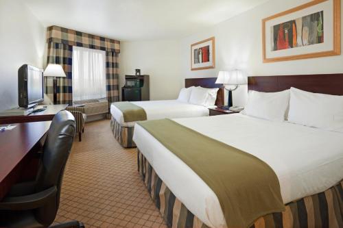 a hotel room with two beds and a desk at Holiday Inn Express & Suites Colorado Springs-Airport, an IHG Hotel in Colorado Springs
