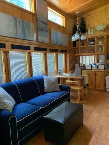 a living room with a blue couch and a table at Knotty but Nice-sleeps 6-one minute to lake! in Three Oaks