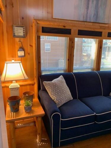 a living room with a blue couch and a lamp at Knotty but Nice-sleeps 6-one minute to lake! in Three Oaks