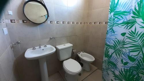 a bathroom with a toilet and a sink and a mirror at La Chakana in Uspallata