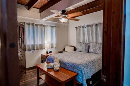 a bedroom with a bed and a ceiling fan at Tres Cocos Resort in San Pedro