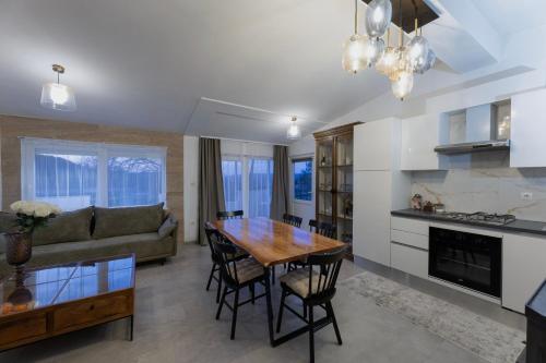 a kitchen and living room with a wooden table and chairs at Family Little Paradise in Ružić